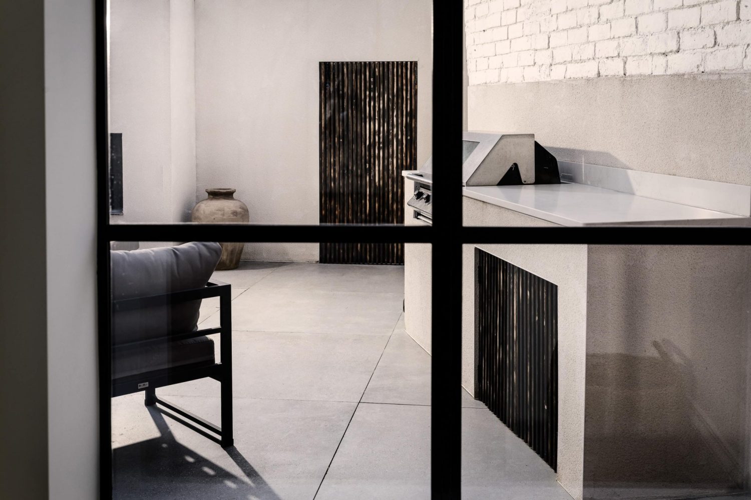View through window to paved outdoor area with counter