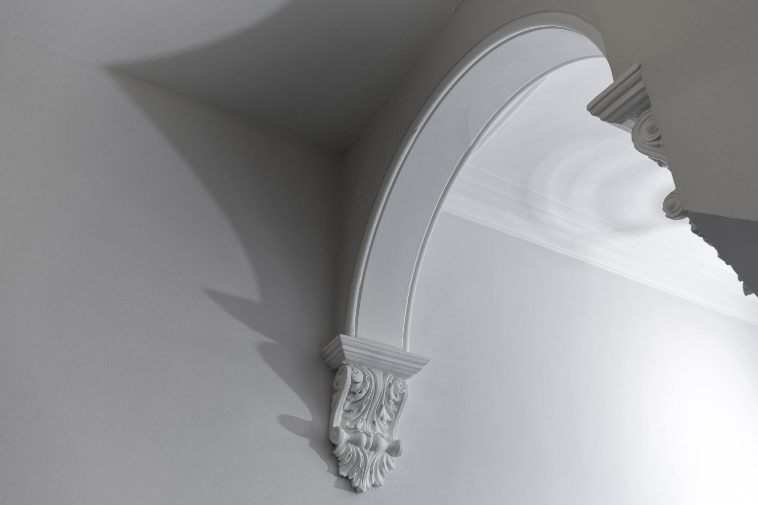 White archway with detail around the edges and white walls and ceiling surrounding
