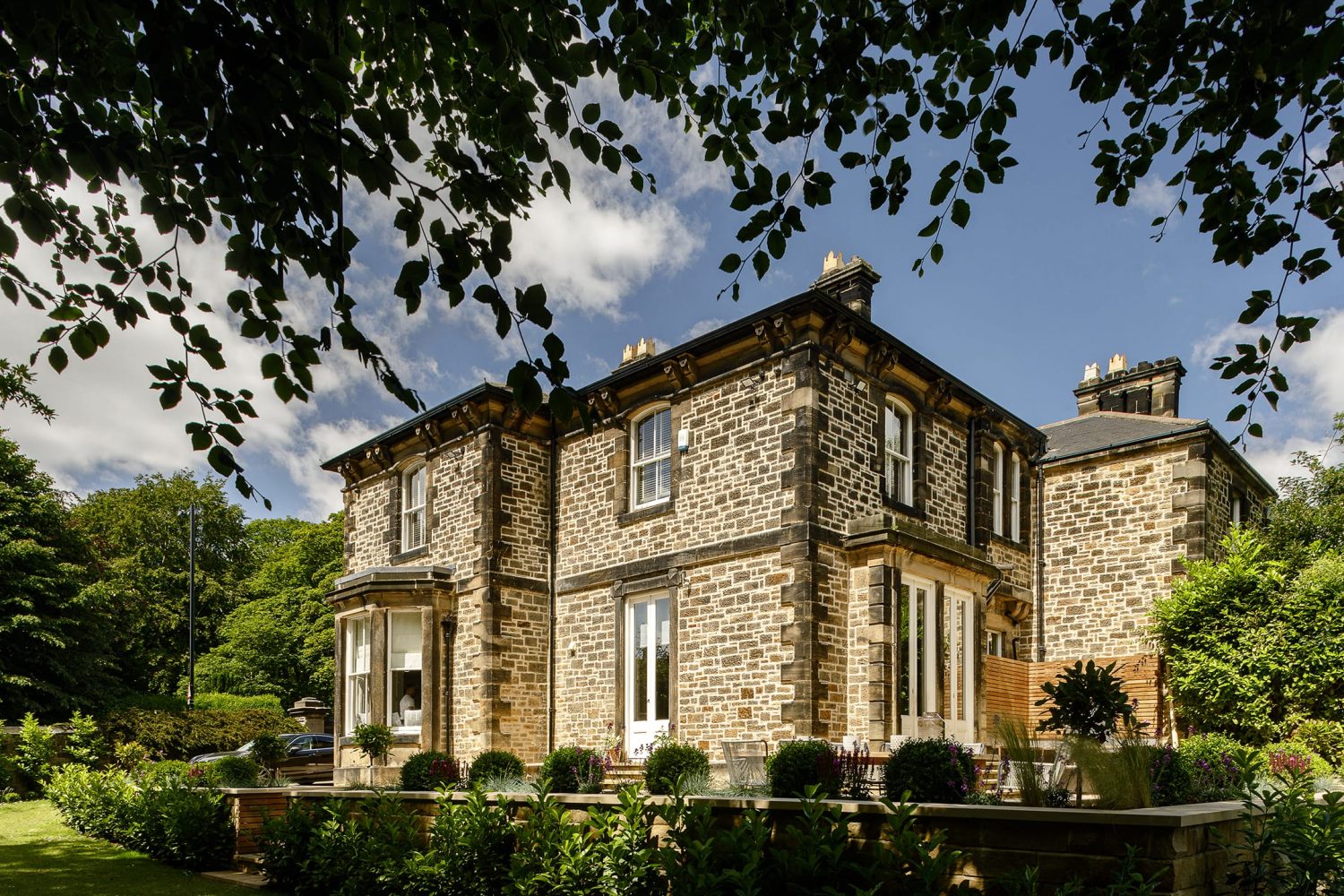 Exterior of stone built house with greenery surrounding