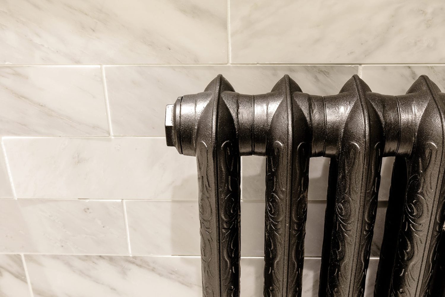 Edge of silver radiator with ornate designs embossed in metal
