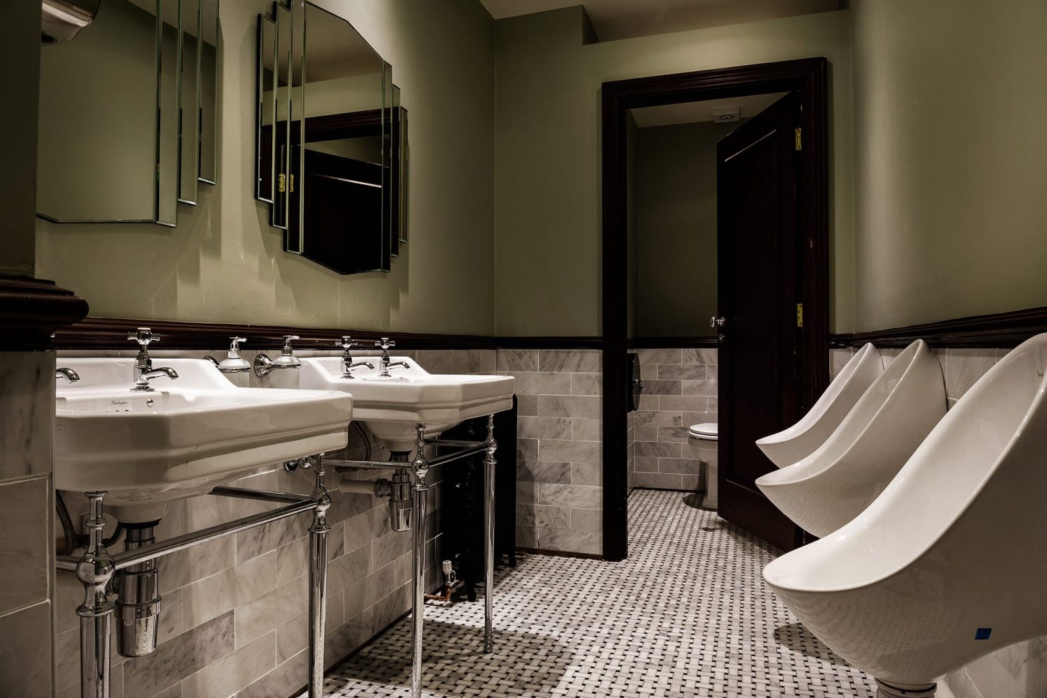 Bathroom with muted green paint above light grey tiles with white and chrome sinks