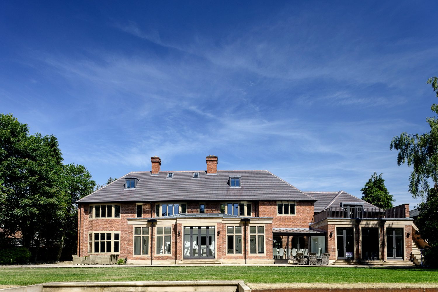 Exterior back of large house with brick walls and slate roof