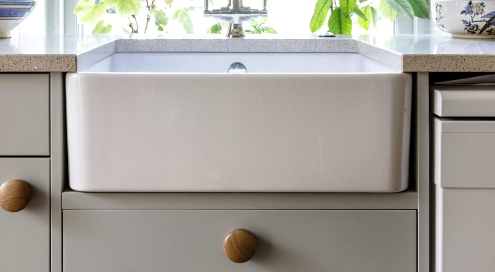 Side of white sink close up with light grey cabinetry surrounding