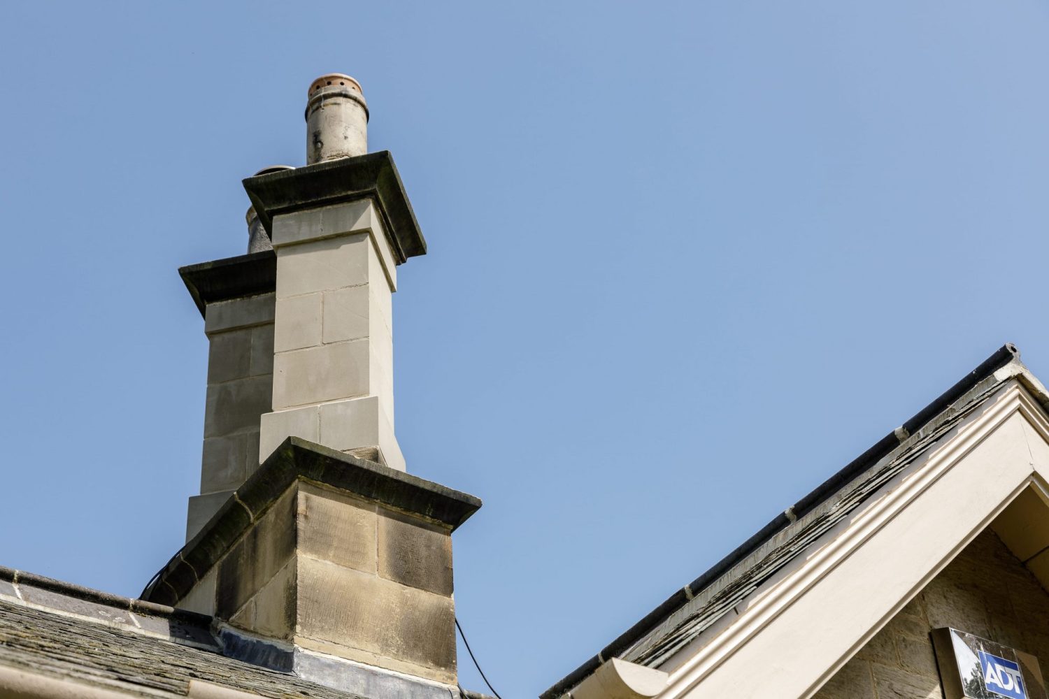 Stone chimneys on top of cottage with blue sky background