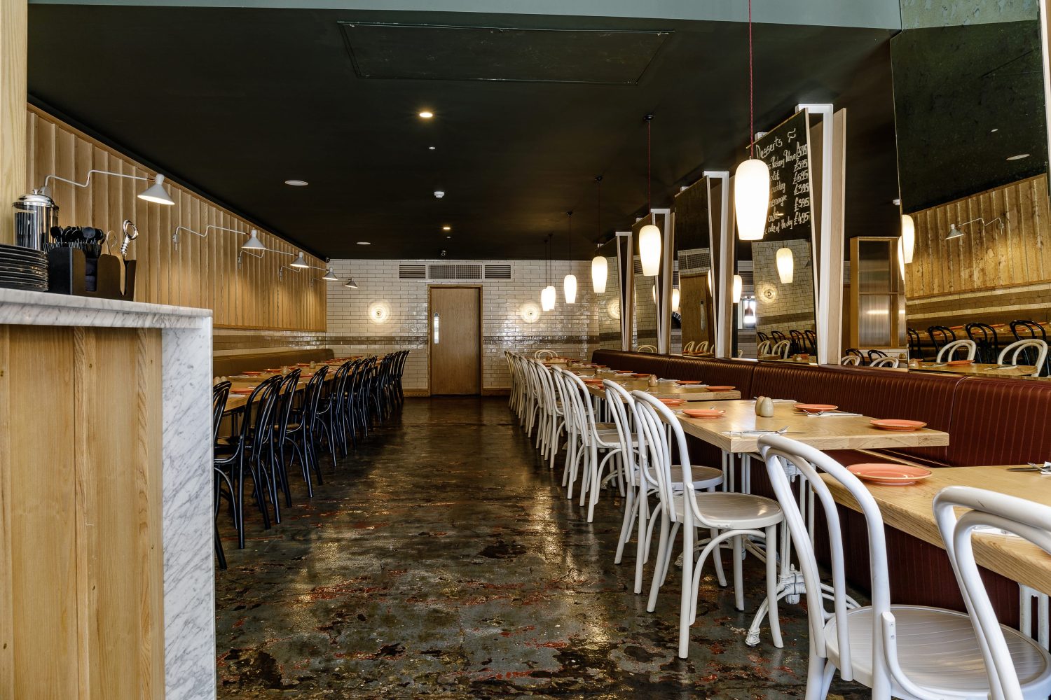 Restaurant seating area with mirrors and pendant lighting