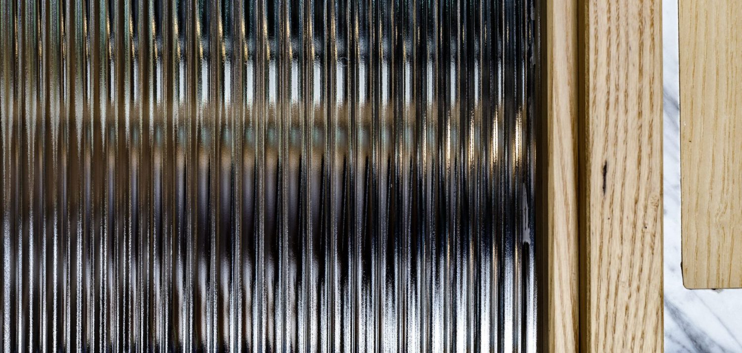 Close up of finned glass partition with wooden accent