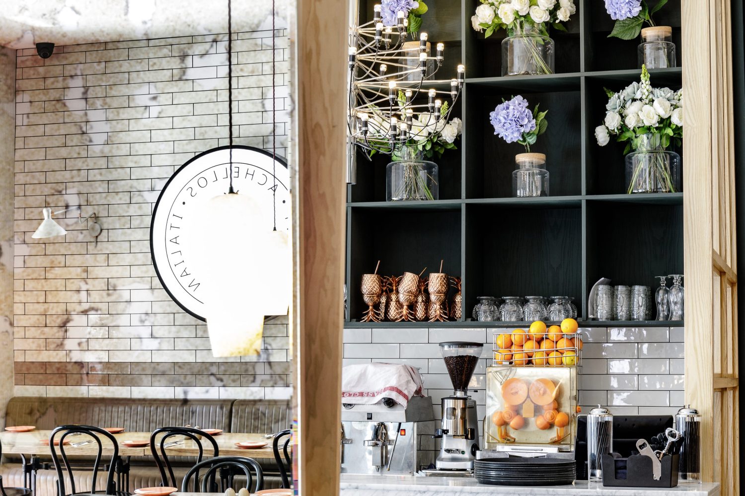 Bar area with floral arrangements and restaurant sign shown in antiqued mirror