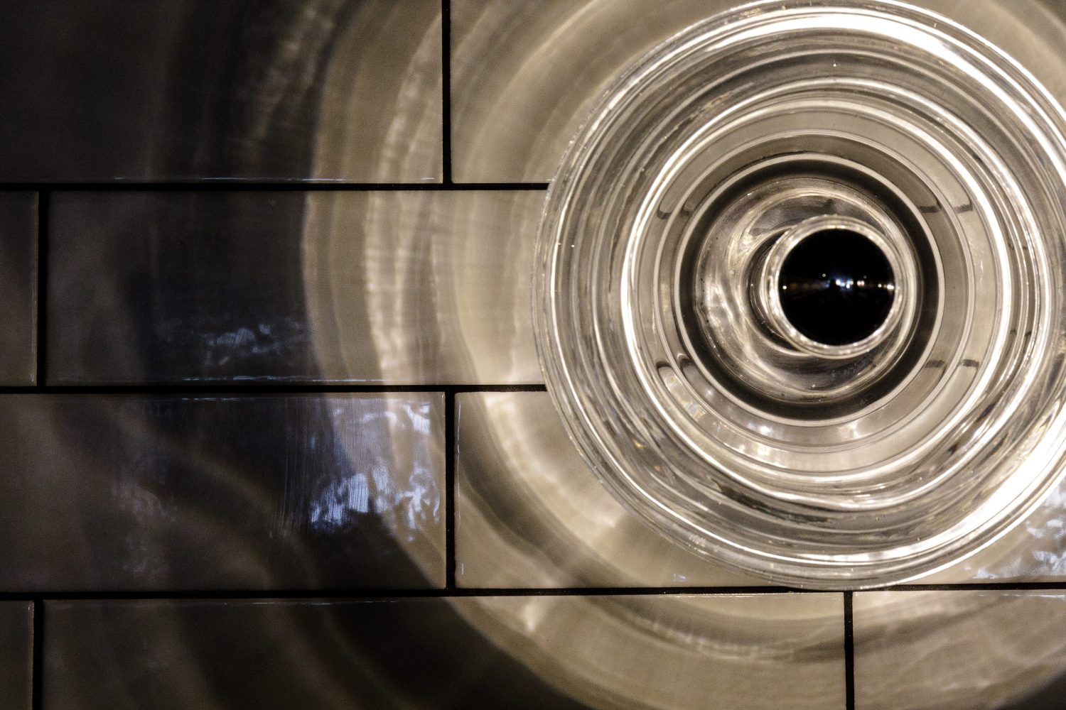 Close up on circular light reflections on tiled wall