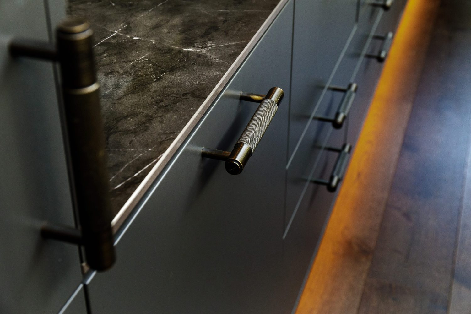 Close up black drawers unit with dark marble countertop and metal handles