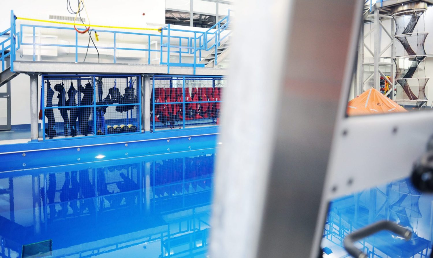 Blue pool with equipment hanging behind blue fences to the side