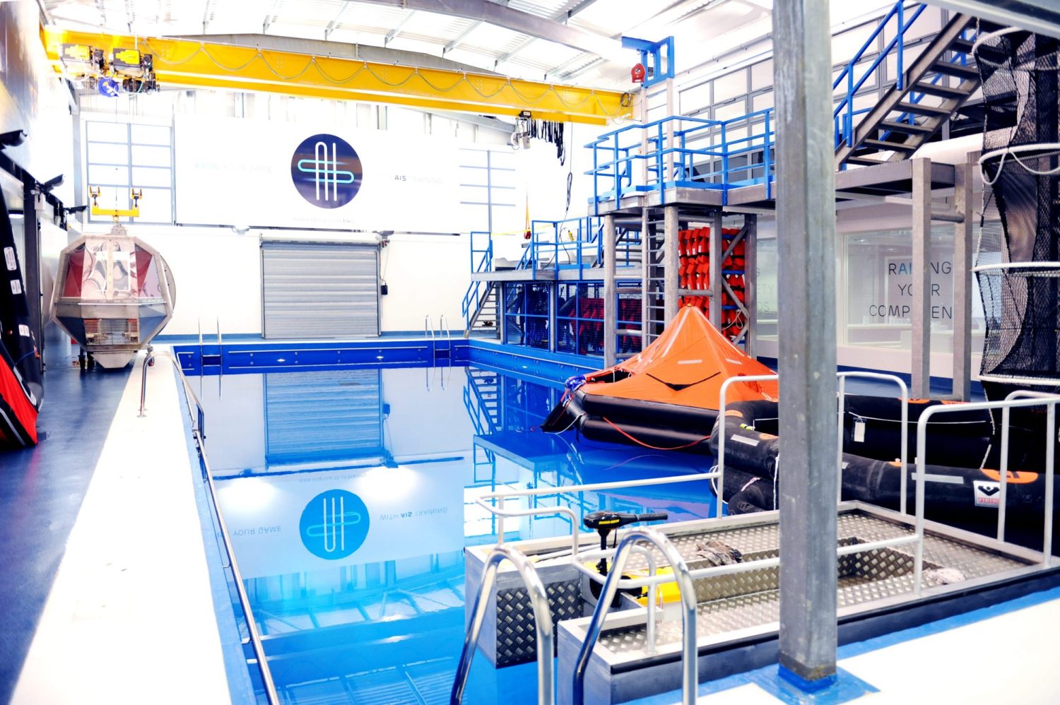 Blue pool with large black and orange equipment floating on top and blue staircases to the side