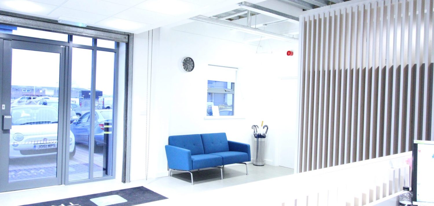 Reception area with white walls, blue sofa and partition wall