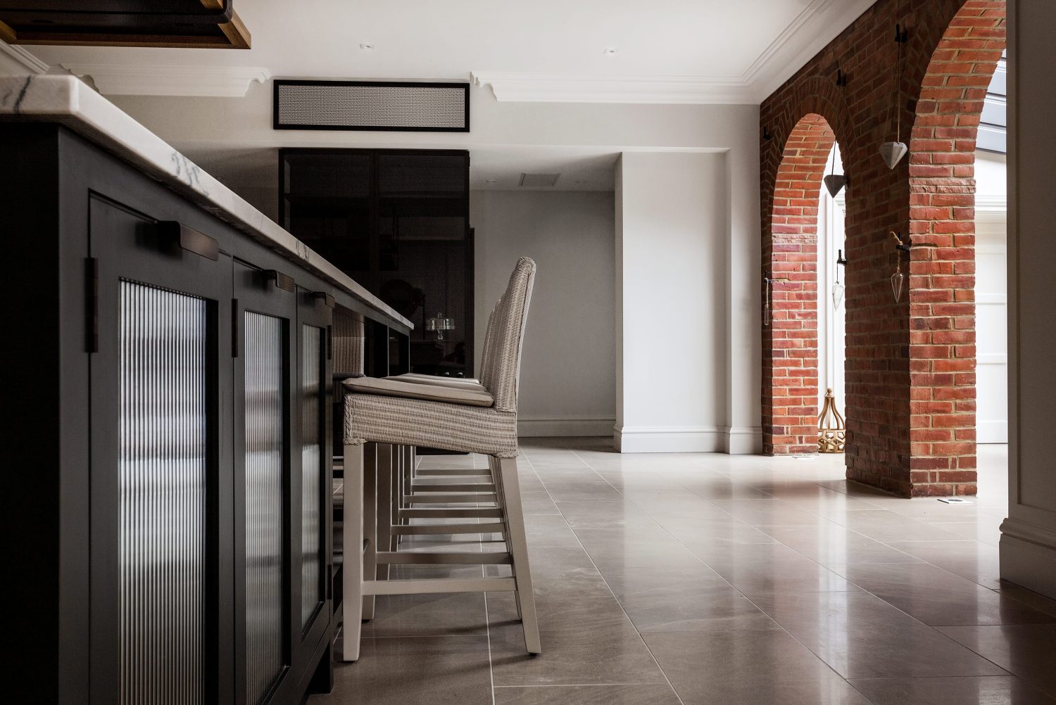 Side view of barstools in a home with brick archways