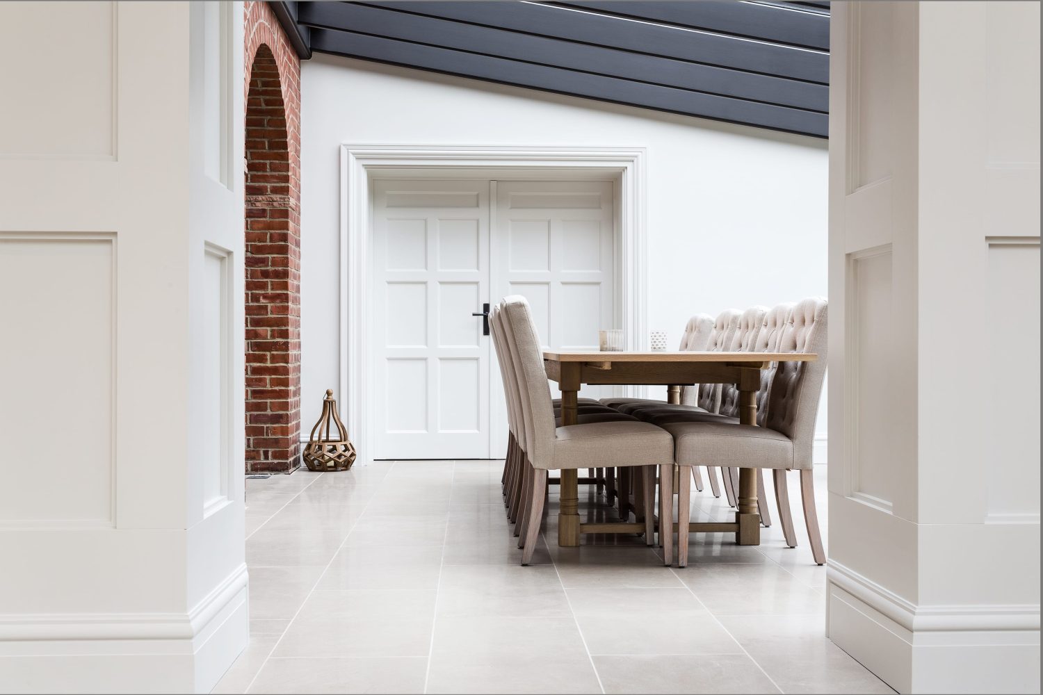 Side view through doorway of wooden dining table with beige chairs