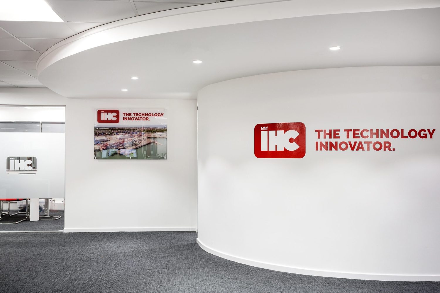 White curved wall with company logo graphics across