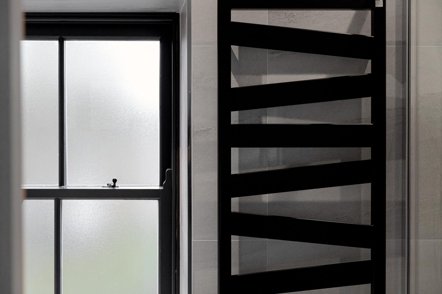 Grey bathroom wall with black abstract radiator