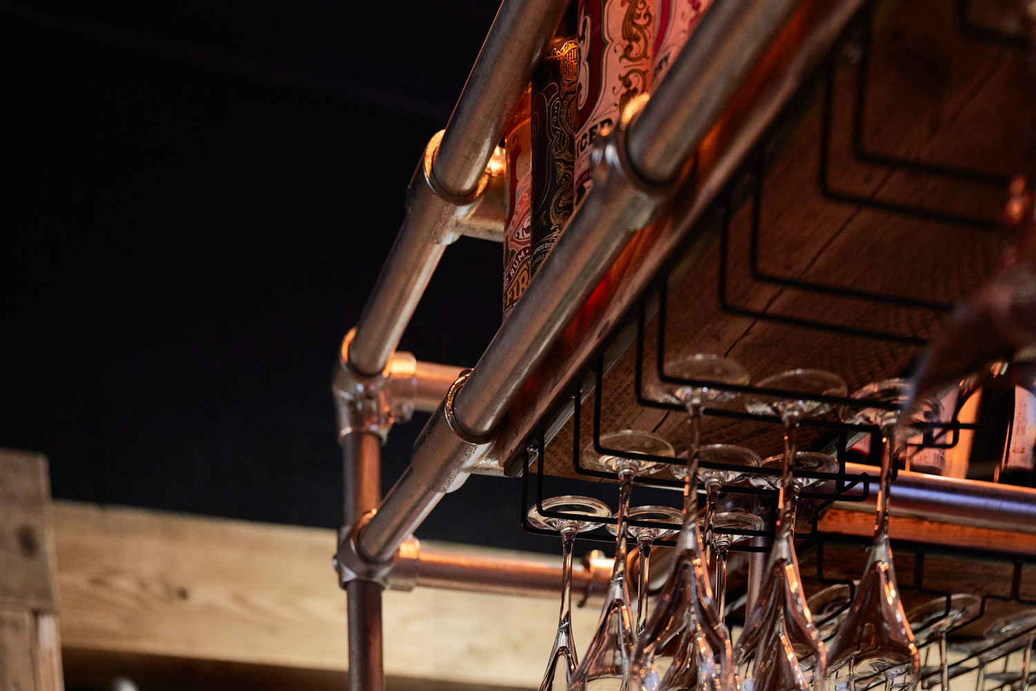 Close up metal bars surrounding shelving holding glasses and bottles