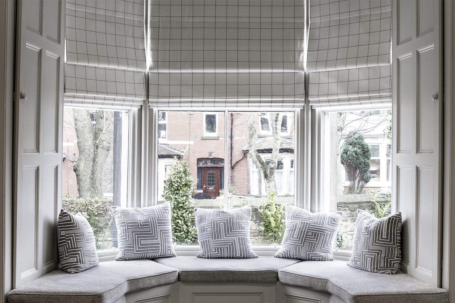 White bay window with grey cushioned window seat