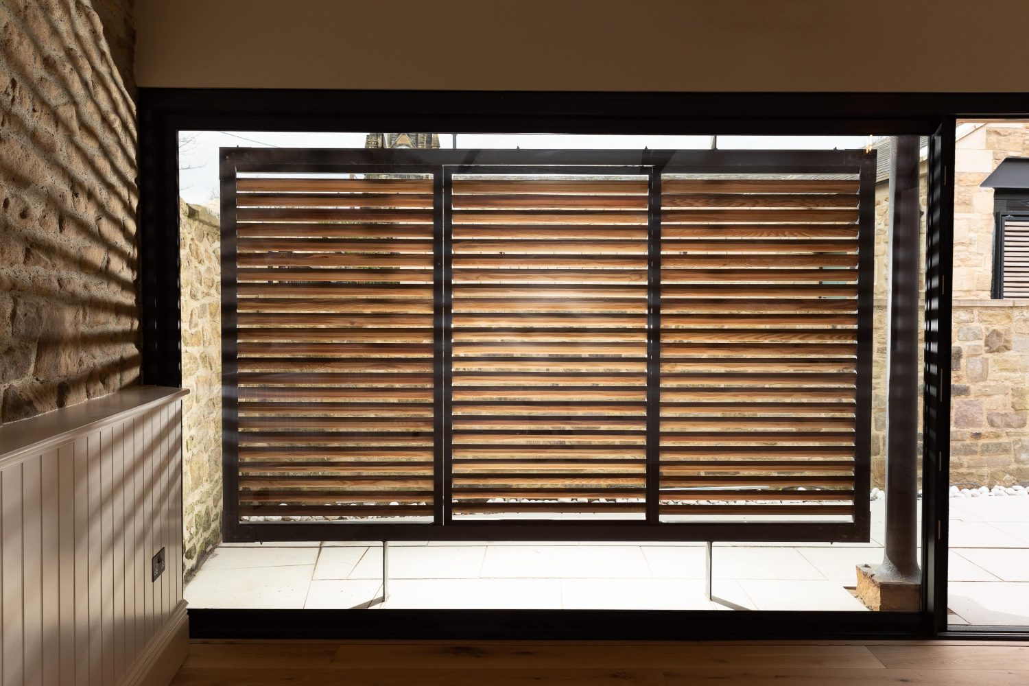 Large window with wooden shutter suspended in front