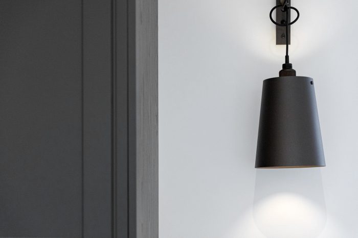 black pendant wall lamp on white wall beside dark grey cabinet