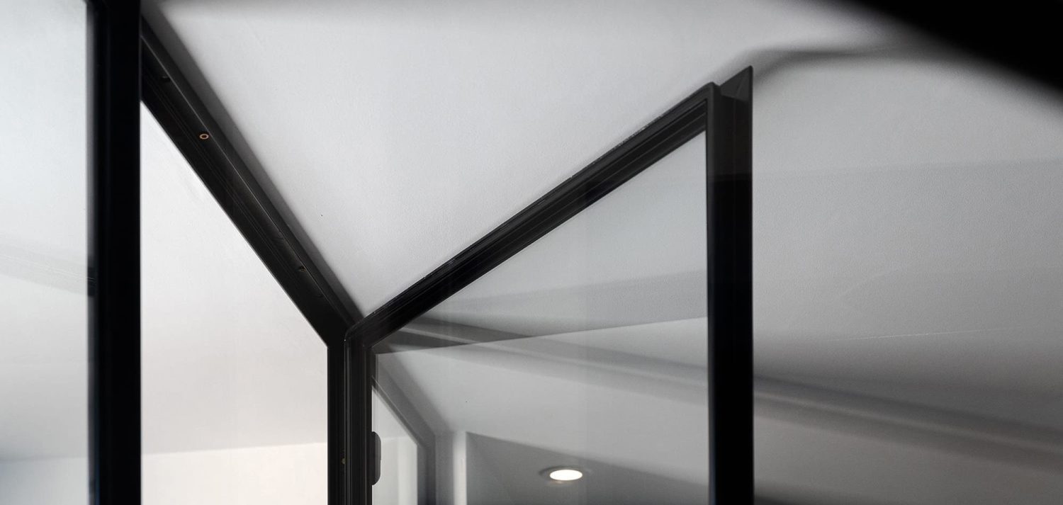Close up corner of glass door open with thin black frame