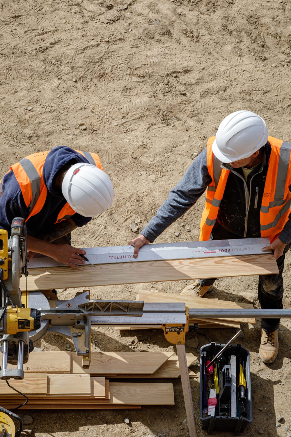 Two builders with white hard hats working