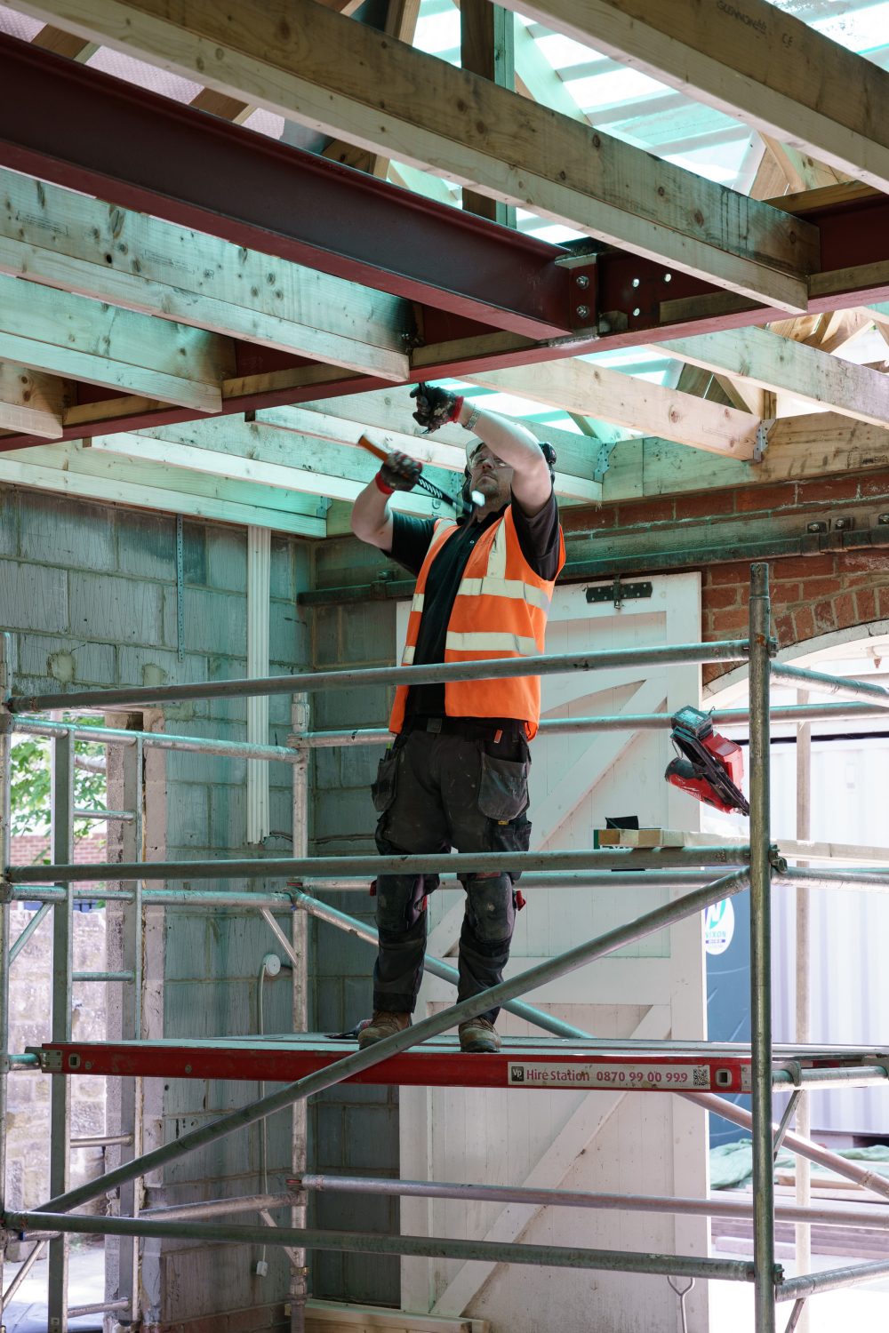 Construction worker in hi vis, working on a platform.
